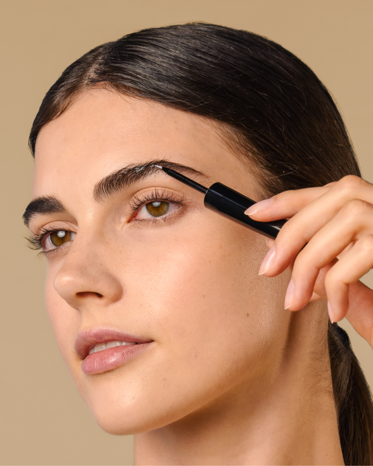 Model applies 8T3 Lash & Brow Serum precisely to the eyebrow