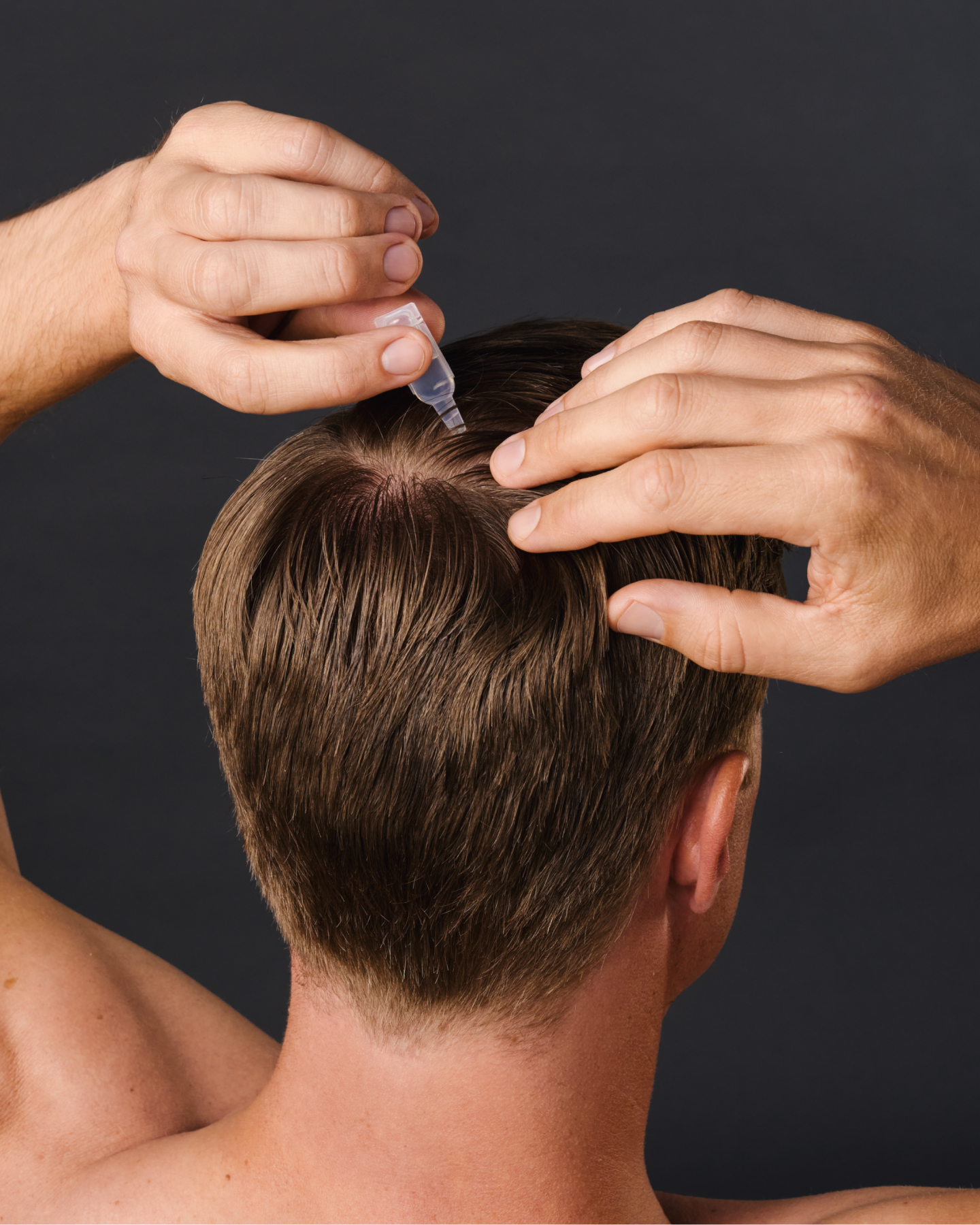 Mann gibt 8T3 Haar-Serum punktgenau auf die Kopfhaut