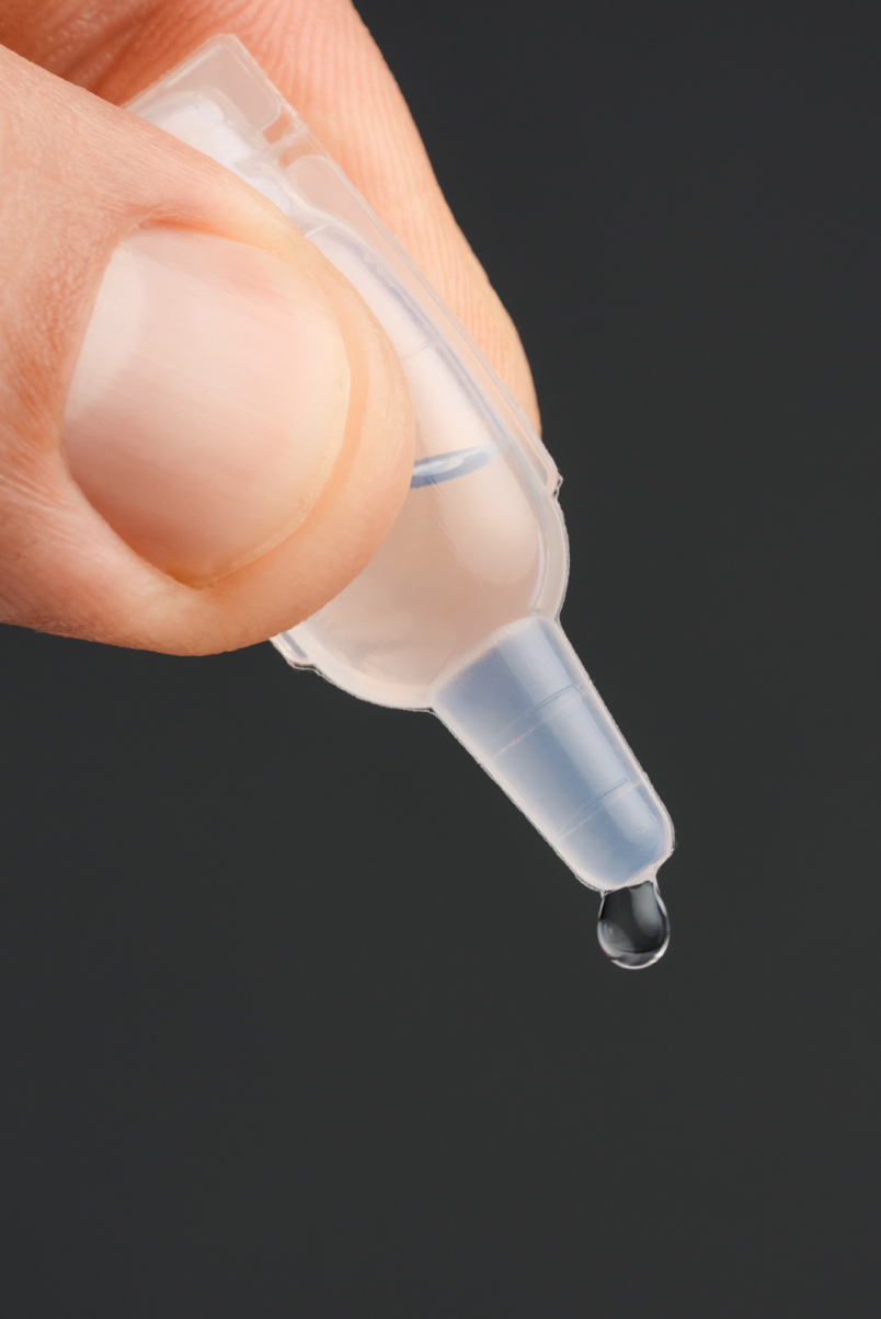 Close-up of ampoule tip with falling drop of 8T3 Hair Serum – precise dosage