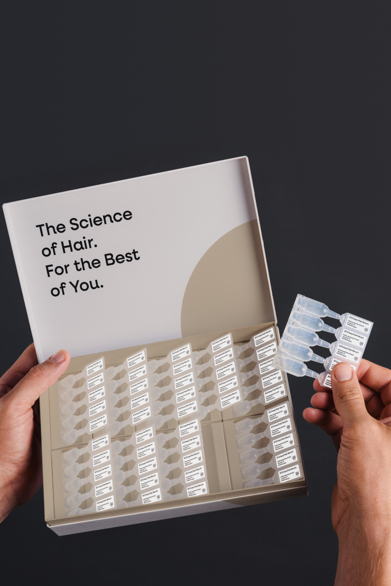 Open storage box with assorted 8T3 Hair Serum ampoules; lid with text 'The Science of Hair. For the Best of You.'
